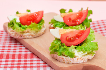 Rice Cake Sandwiches with Tomato, Lettuce and Egg on Wooden Cutting Board. Easy Breakfast. Diet Food. Quick and Healthy Sandwiches. Crispbread with Tasty Filling. Healthy Dietary Snack