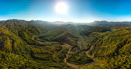 river valley near the Anastasievka farm in the forested mountains of the Western Caucasus on a cloudy day in early autumn - aerial panorama