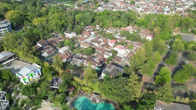 Aerial view of Jogja City with buildings, crowded vehicles traffic in morning sunlight. Sleman cityscape urban landscape. Population density is displacing agricultural land and forests.