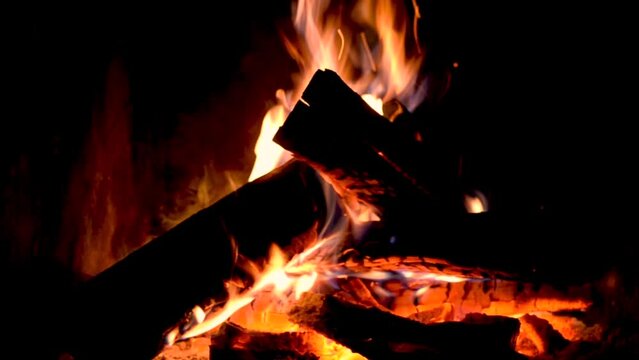 The fire burns in the fireplace, closeup. The flames are licking the wood in the fireplace. The atmosphere of coziness and comfort in the evening close-up. Hearth