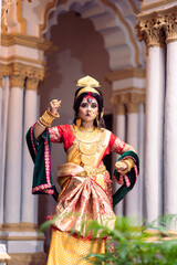Beautiful young woman dressed as Hindu goddess Durga , She is wearing Banarasi Saree and heavy gold Jewellery. Traditional Dancer dressed as Devi Durga.