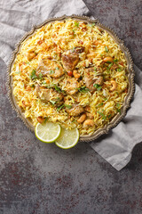Kacchi Mutton Biryani is a delicious rice dish where tender lamb meat pieces are marinated with lots of spicy closeup on the plate on the table. Vertical top view from above