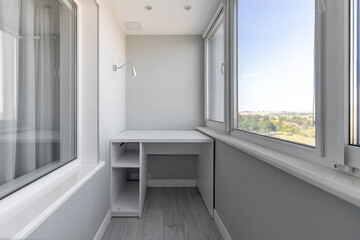 Modern interior of the loggia of white color with lighting, table and window - obrazy, fototapety, plakaty