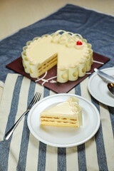 Vanilla Cake slice include cream, sugar, red berry served in plate isolated on napkin side view of cafe food
