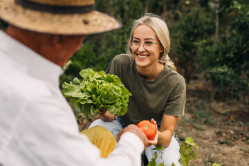 Young woman giving lettuce and tomato to her grandfather.