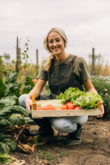 Happy Caucasian woman picking vegetables from her eco garden.