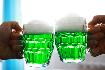 Saint Patrick's Day holiday. National Irish holiday. Green beer. Hand with a mug of emerald beer in...