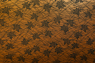 Maple leaf pattern texture on brown and gold color interior wallpaper in Japanese traditional hotel room decorative for Autumn Fall seasonal