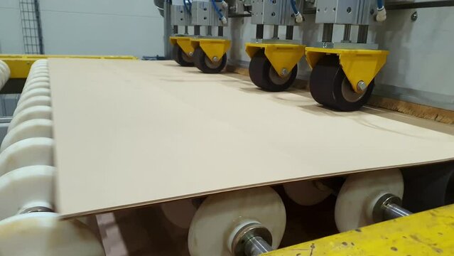 Laminated insulation cardboard production process. Raw materials for laminated cardboard. Electric cardboard travels along the conveyor line. Automated line in production. Roller conveyor. Sphere of t