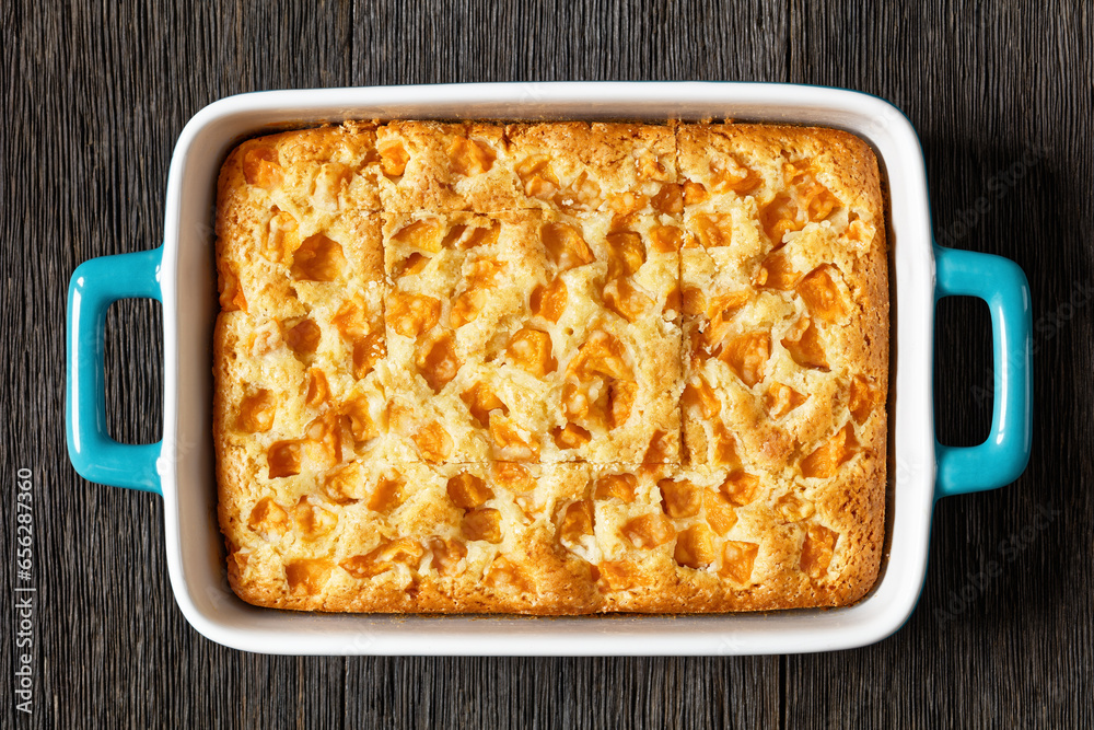 Wall mural peach cake in baking dish on dark wooden table