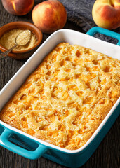 peach cake in baking dish on dark wooden table
