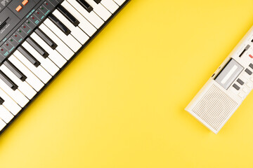 Vintage electronic keyboard synth piano on yellow background