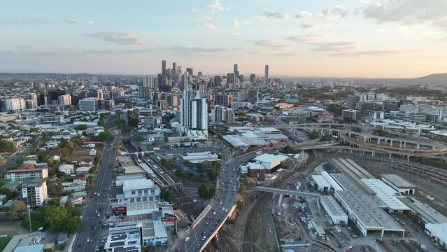 Establishing push in shot of Brisbane City, with Mayne Railway Yard and the ICB inner city bypass and Brisbane Showgrounds. Shot during sunset, city Skyline standing tall against lovely sunset sky.