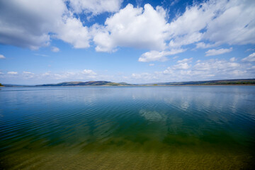 beautiful landscape with clouds reflecting on a lake during the day