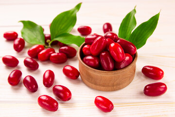 Cornela berries, on a white wooden background. Dogwood berries.