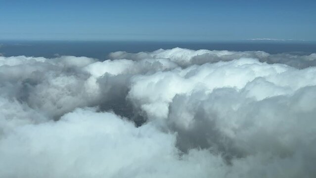 Overflying some fluffy clouds as seen by pilots during the descend, 5000m high. A pilot’s perspective.