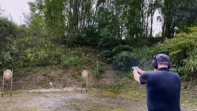 Man Training with a Handgun Dynamic Shooting in an Outdoor Shooting Range in a Sunny Day. (Audio)