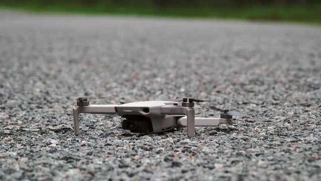 View of a small quadcopter landing on the ground. Drone on the road.
