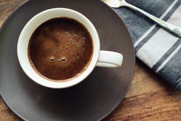 Cup of coffee on rustic wooden background. Soft focus. Close up. Copy space