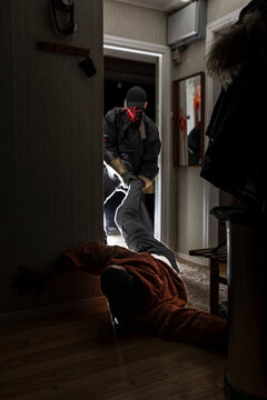 Demon wearing mask pulling man in cabin