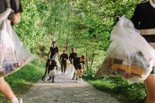 Volunteers plogging on footpath amidst plants