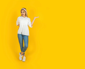Woman offering new product, full body view  young caucasian blonde woman offering new product. Happy smiling girl holding copy space on her open palm. Product display advertising concept idea image.