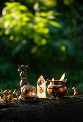 wiccan Goddess ritual figurine with witch cauldron and crystals in forest, dark abstract natural...