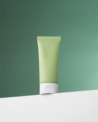 Trendy composition with bottle on podium. Bottle cosmetic tube on white podium on green background....
