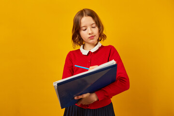 Thoughtful School teenage girl holding pen and write on notebook