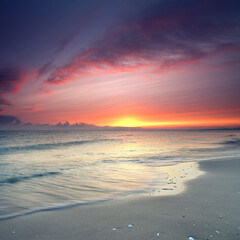 leuchtender Sonnenuntergang am Strand am Meer
