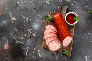 Smoked sausage salami with slices on a dark background. banner, menu, recipe place for text, top view