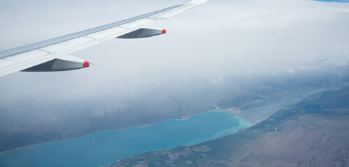Fototapeta premium Aerial view of Lake Pukaki in heavy fog, from an airplane flying from Auckland to Queenstown. South Island.