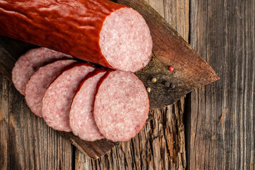 Salami sausage slices on a wooden board. banner, menu, recipe place for text, top view - obrazy, fototapety, plakaty