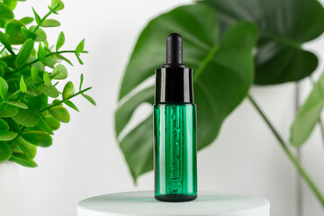 Green glass serum on white square podium stage and monstera leaves. Skincare product ad mockup cosmetic on white background. Minimalist scene..