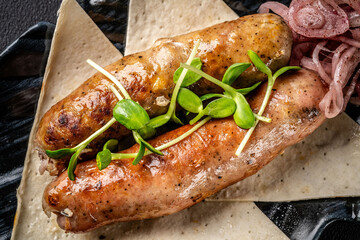 Turkish cuisine. Grilled beef sausages lie on a plate with pita bread and pickled onions