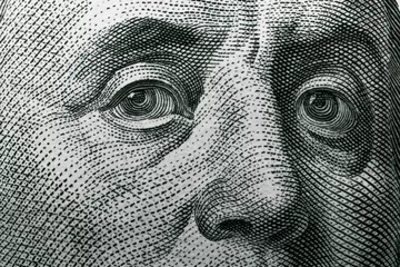Fotobehang Benjamin Franklin's eyes on a hundred dollar bill. Benjamin Franklin portrait. United States national currency banknote fragment © Klochkov
