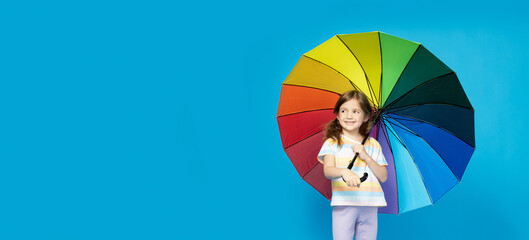 A little girl with a colorful umbrella in her hands