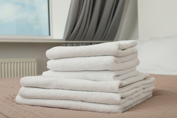 Neatly folded white towels on the bed