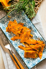 Pumpkin cut into slices and baked with rosemary and extra virgin olive oil - 656375915