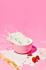 Bowl with splashing milk, cereal, muesli and strawberries against pink background. Healthy breakfast. Concept of healthy food, nutrition, pop art style, taste. Poster. Copy space for ad