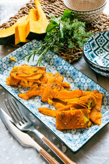 Pumpkin cut into slices and baked with rosemary and extra virgin olive oil - 656376978