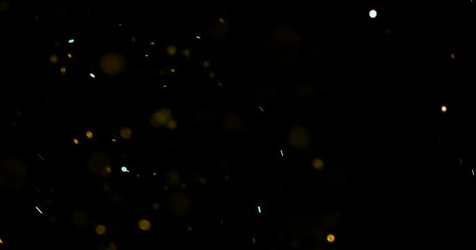 gold glow particles bokeh sparkle glittering on black background, holiday christmas new year celebration