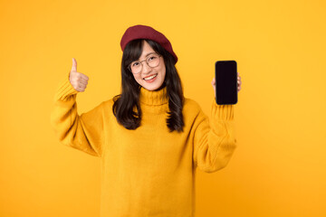 Ethnic woman with a smartphone, showcasing thumb up gesture, in a trendy yellow setting, wearing a red beret and eyeglasses. - obrazy, fototapety, plakaty