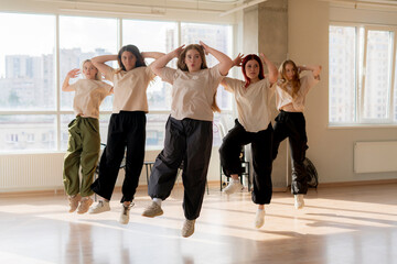 girls dancing crew in the gym jump in the air, choreo, synchrone moves