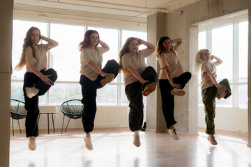Fototapeta premium girls dancing crew in the gym jump in the air, choreo, synchrone moves