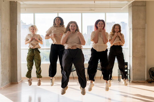 girls dancing crew in the gym jump in the air, choreo, synchrone moves