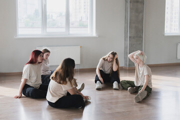 young female dancers tired and exhausted after practice session in the class