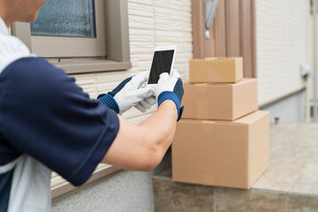 玄関先に荷物を届けたことを知らせる配達員