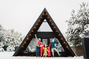 Big family with kids have fun on terrace of mountain country house in snow forest together. Company...