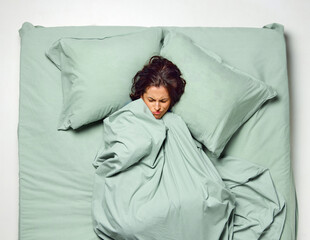 Young stressful, scared woman covered with blanket in dream lying in bad. Nightmares, restless...